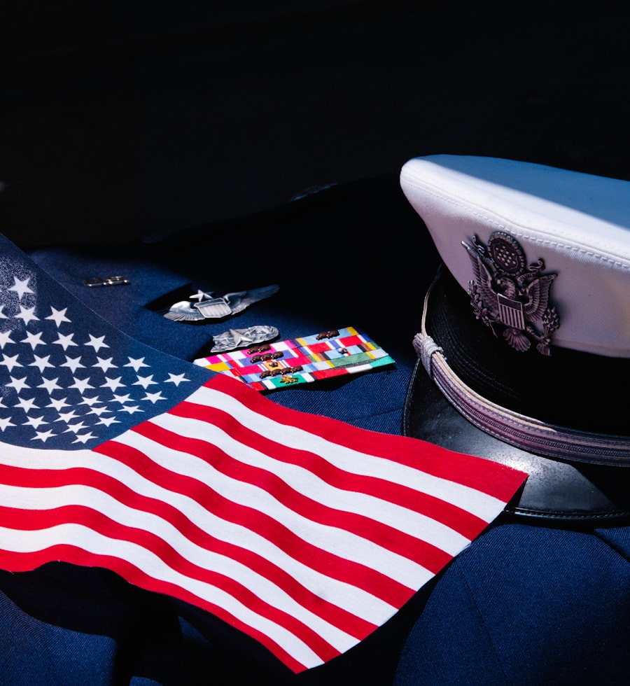 A folded United States flag beside a military service cap and campaign ribbons